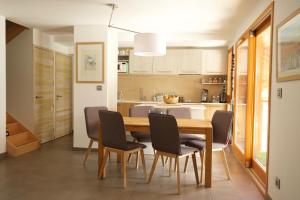 a kitchen and dining room with a wooden table and chairs at L'Eyssaben Appartement de grand standing à Serre-Chevalier in Le Monêtier-les-Bains