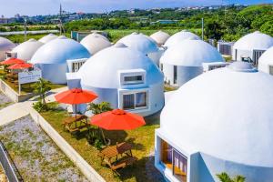 a group of domes with chairs and umbrellas at Uruma Dome Okinawa in Uruma