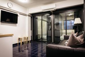 a living room with a couch and a tv at T2 2 Bedrooms 6 guests Full kitchen 1 min to BTS in Bangkok