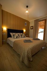 a bedroom with a large bed with two pillows on it at L'Eyssaben Appartement de grand standing à Serre-Chevalier in Le Monêtier-les-Bains