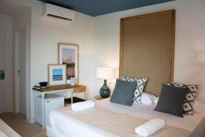a bedroom with a large white bed and a desk at YOU & CO. Saler Beach Boutique in Valencia