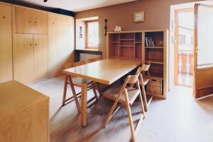 a dining room with a wooden table and chairs at MAISON LINDA in Sottoguda