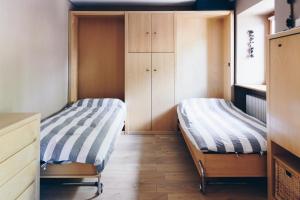 a bedroom with two beds and wooden cabinets at MAISON LINDA in Sottoguda