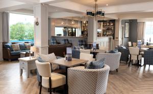 a restaurant with tables and chairs and a bar at Loch Ness Clansman Hotel in Drumnadrochit