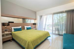 a bedroom with a large bed and a large window at Atrion Resort Hotel in Agia Marina Nea Kydonias
