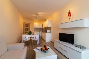 a living room with a white couch and a table at Varna South Bay Beach Residence in Varna City