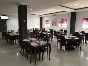 a dining room filled with tables and chairs at Hotel Arisu in Serang