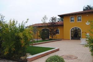 une grande maison jaune avec une cour dans l'établissement I Filari, à Valeggio sul Mincio