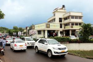 a group of cars driving down a busy city street at Hotel Manik Moti in Lonavala