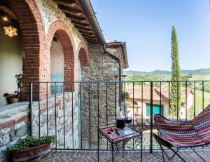 eine Terrasse mit 2 Stühlen und einem Tisch auf dem Balkon in der Unterkunft Rietine24 in Gaiole in Chianti