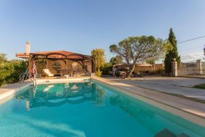 a swimming pool with a gazebo in a yard at Pool villa near to airport/free car available in Pikérmion