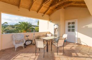 a patio with a table and chairs and a window at Pool villa near to airport/free car available in Pikérmion