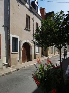 una calle vacía con un edificio y un árbol en Le sourire de Mona Lisa 2 étoiles 100m du château, en Amboise