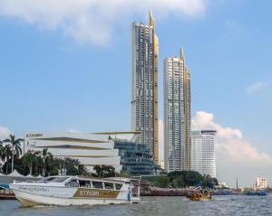 T5 2 Bedrooms/6guests/full kitchen/1 min to BTS في بانكوك: وجود قارب في الماء امام بعض المباني