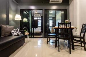 T5 2 Bedrooms/6guests/full kitchen/1 min to BTS في بانكوك: غرفة معيشة مع أريكة وطاولة وكراسي