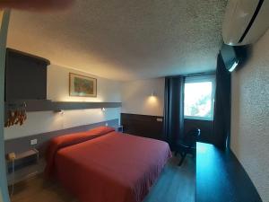 a bedroom with a red bed and a window at Hotel les Tourrades in Cannes