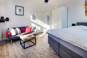 1 dormitorio con 1 cama grande y 1 sofá en Herr Friese, Wohnung Nr. 6, en Norderney