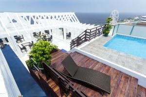 a deck with chairs and a swimming pool and the ocean at Microtel by Wyndham Mall of Asia in Manila