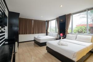 Habitación de hotel con 2 camas y ventana grande. en Royal Beach Residence, en Patong Beach