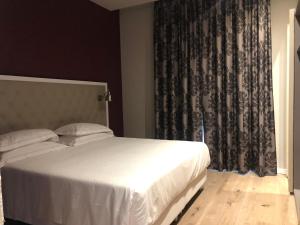 a bedroom with a white bed and a curtain at Zanhotel Regina in Bologna