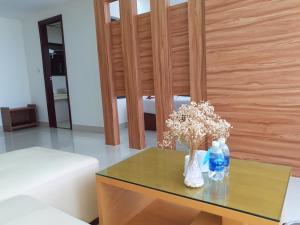 a table with a vase of flowers and bottles on it at Phu Cuong Beach Hotel in Dong Hoi