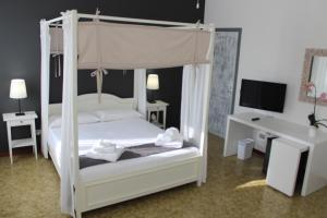 a bedroom with a white canopy bed and a desk at B&B Il Ponticello in Gualtieri