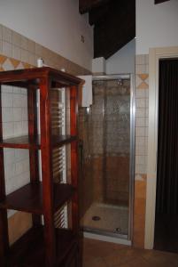 La salle de bains est pourvue d'une douche avec une porte en verre. dans l'établissement I Filari, à Valeggio sul Mincio