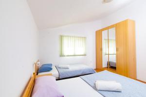 a bedroom with two beds and a mirror at Apartmani Villa Mimi in Brodarica