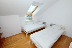 een zolderkamer met 2 bedden en een raam bij Apartament Słoneczny 2 in Opole