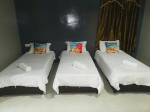 two beds with stuffed animals on them in a room at Riverbank Dungun Guesthouse & Cafe in Dungun