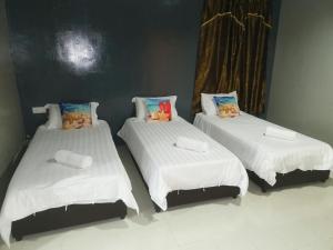 two beds with stuffed animals on them in a room at Riverbank Dungun Guesthouse & Cafe in Dungun