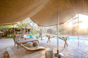 ein großes Zelt mit einer Bank und einem Tisch in der Unterkunft Sitatunga Campsite Maun in Maun