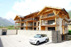 a white car parked in front of a building at L'Eyssaben Appartement de grand standing à Serre-Chevalier in Le Monêtier-les-Bains