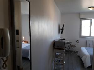 a small room with two beds and a television at Appartement Studio Gare SNCF in Beauvais