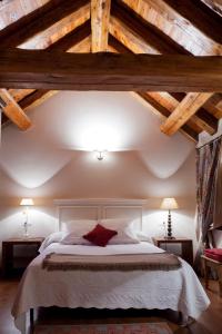 a bedroom with a large white bed with wooden ceilings at Apartamentos Russell in Torla-Ordesa
