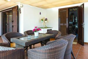 comedor con mesa y sillas de mimbre en Villa Bellamar en Puerto del Carmen