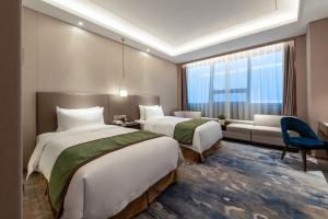 Postel nebo postele na pokoji v ubytování Auto City Ruili Hotel