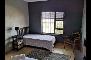 a bedroom with a bed and a window and a chair at Eagle's Crest in Worcester