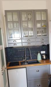 a kitchen with white cabinets and a sink and a counter at Apartament Różany in Karpacz