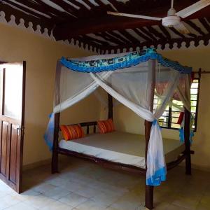 A wonderful Beach property in Diani Beach Kenya.a dream holiday place. في مومباسا: غرفة نوم مع سرير بطابقين مع مظلة