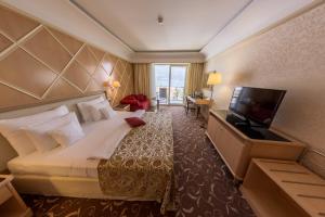 ein Hotelzimmer mit einem Bett und einem Flachbild-TV in der Unterkunft Splendid Conference & Spa Resort in Budva