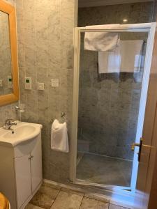 ein Bad mit einer Dusche und einem Waschbecken in der Unterkunft Troy Hotel in London