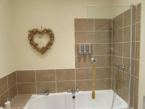 a bathroom with a bath tub with a heart shaped mirror at Apartment 5 - two bedroom luxury apartment close to town, mainline rail & theatre stylish and comfortable in Darlington