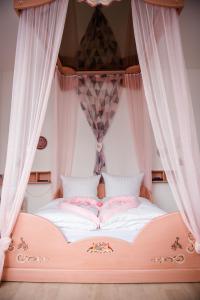 Allmanns-Kroog في Sterup: سرير مغطى وردي مع ستائر بيضاء في غرفة النوم