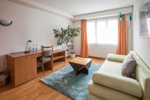 ein Wohnzimmer mit einem Sofa und einem Schreibtisch in der Unterkunft Hotel Zur Au in Dällikon