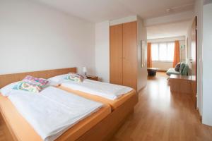 um quarto com uma cama grande com lençóis brancos e almofadas em Hotel Zur Au em Dällikon