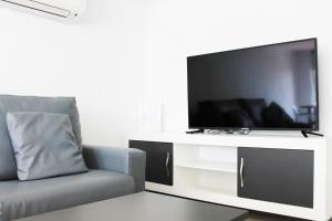 sala de estar con TV de pantalla plana grande en Apartamentos Tamarindos Peñiscola, en Peñíscola