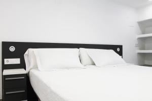ペニスコラにあるApartamentos Tamarindos Peñiscolaの白いベッド(白い枕付)が備わるベッドルームです。
