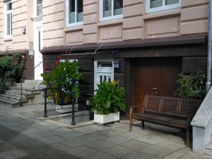 a bench and plants in front of a building at DARZ GästeZimmer in Hamburg