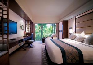 ein Hotelzimmer mit einem Bett, einem Schreibtisch und einem Fenster in der Unterkunft Shangri-La Mactan, Cebu in Mactan